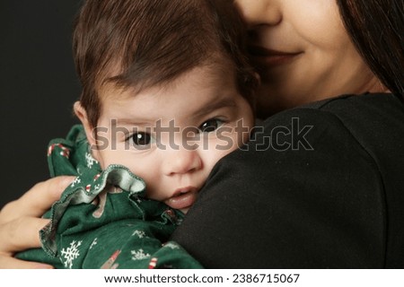 Close up studio portrait of mother holding her little baby girl