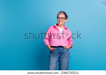 Portrait of cheerful positive person wear stylish blouse in eyewear look at promotion empty space isolated on blue color background