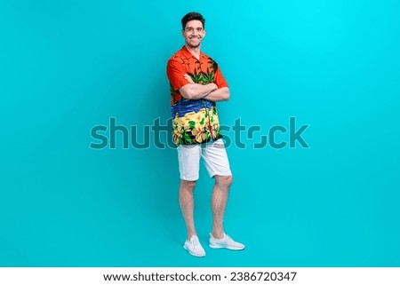 Full length photo of satisfied man with stylish hairdo dressed print shirt standing arms crossed isolated on blue color background