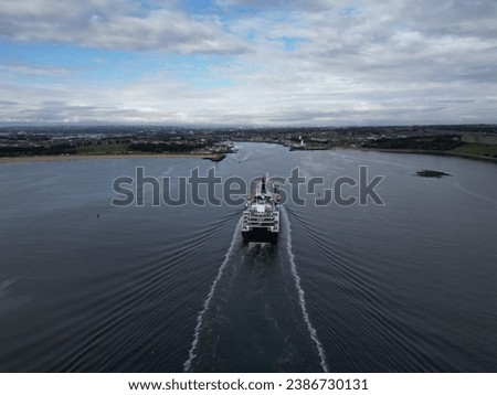 An aerial shot of a large boat sailing across a peaceful body of water during the daytime.