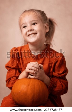 Nice little girl with a pumpkin. This photo has been taken in Prague, 2023