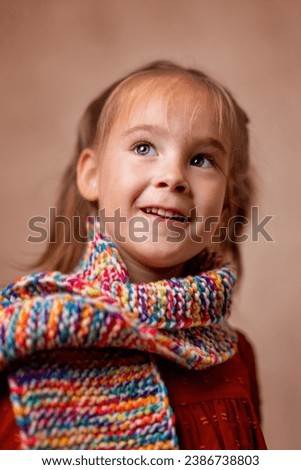A pretty little girl in a colorful scarf. The photo was taken in Prague in 2023.