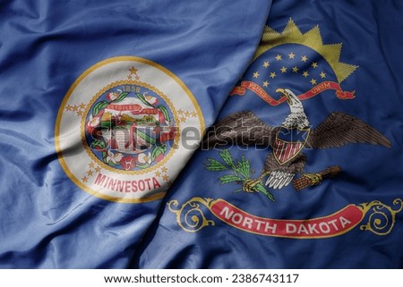 big waving colorful national flag of north dakota state and flag of minnesota state . macro