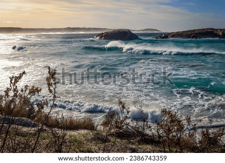 A stormy beach scene at high tide with beach erosion. Twilight Cove Esperance Western Australia.