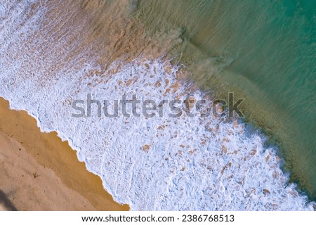 Bird eye view seashore with big wave crashing on sandy shore. Beautiful waves sea surface in sunny day summer background, Amazing seascape top view seacoast landscape view