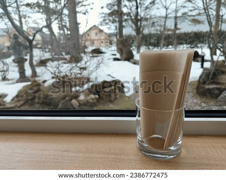 a glass of tissues near a window