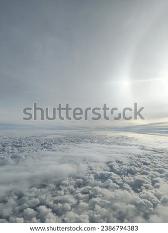 picture of beautiful sky with clouds with sun lens flare. shot from an airplane window
