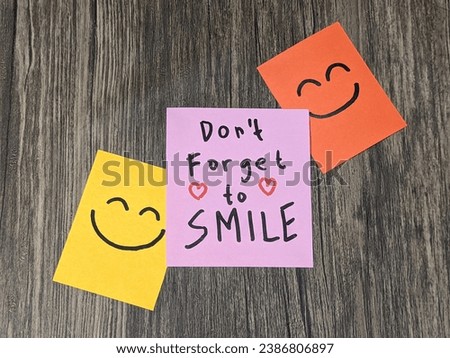 Happiness emoticon face on paper. Encouragement and motivational quotes. Encouragement word on pink paper. Handwritting. Wooden background