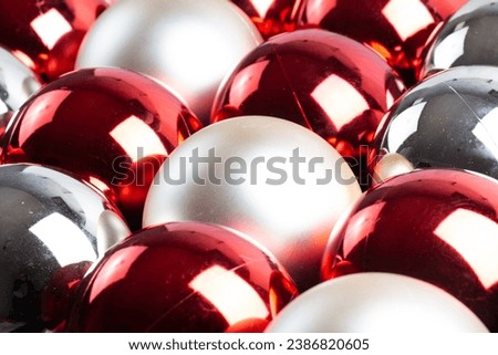 Christmas mirror balls, full frame background of red, silver and white, close-up with selective focus.