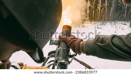 Mortar Shooting Explosions Forest. Close-up View On Re-enactors Dressed As American Infantry Soldiers Fire From Mortar. Usa Army Soldiers Of World War Ii. Reconstruction Defense Battles. Heroes Of War Royalty-Free Stock Photo #2386833977