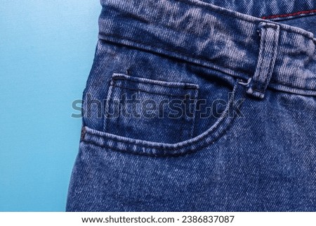 Front pocket of blue denim jeans with prominent stitching. Close up of jeans with lots of pockets