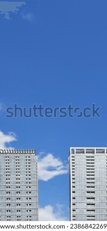 Two apartment buildings with blue sky and slightly cloudy during the day Royalty-Free Stock Photo #2386842269