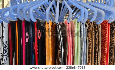 Colorful clothes on hangers for sale in local street market, close image.