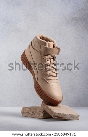 Beige leather casual boots on gray background. Ñreative photography for an advertising poster for footwear commercials