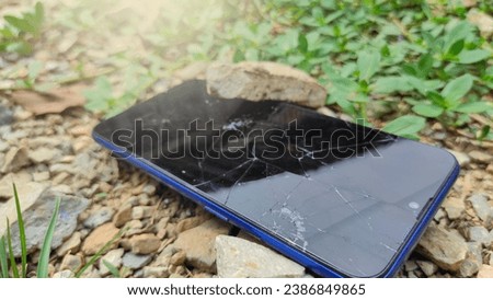 selective focus Smartphone with broken screen dropped on outdoor rocks