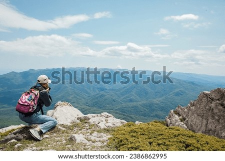Woman on a hike photographing mountains, nature, tourism