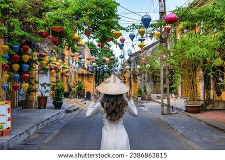 Asian woman wearing vietnam culture traditional at Hoi An ancient town, Vietnam. Hoi An is one of the most popular destinations in Vietnam  from Korea, Thailand, USA, Japan, China
 Royalty-Free Stock Photo #2386863815