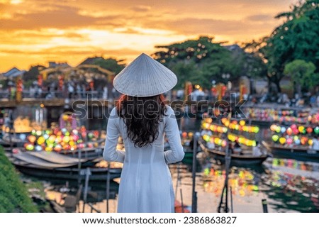 Asian woman wearing vietnam culture traditional at Hoi An ancient town, Vietnam. Hoi An is one of the most popular destinations in Vietnam  from Korea, Thailand, USA, Japan, China Royalty-Free Stock Photo #2386863827