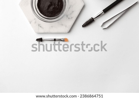 Flat lay composition with eyebrow henna and professional tools on white background, space for text