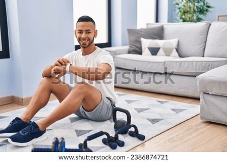 African american man smiling confident looking watch at home