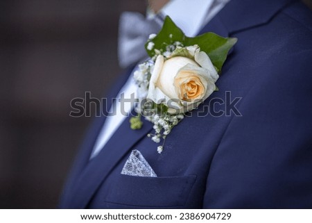 close-up of the groom's flower decoration on his suit during the wedding preparations