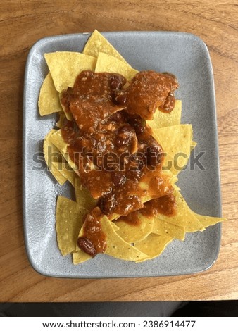 A picture of  nachos which is a Mexican dish consisting of tortilla chips or totopos covered with sauce