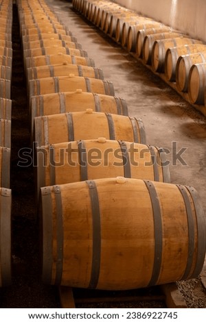 WIne celler with french oak barrels for aging of red wine made from Cabernet Sauvignon grape variety, Haut-Medoc vineyards in Bordeaux, left bank of Gironde Estuary, Pauillac, France Royalty-Free Stock Photo #2386922745