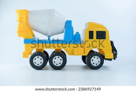 Yellow cement truck isolated on white background. Plastic child toy on white backdrop. Construction vehicle. Children's toy. Tractor Toy.