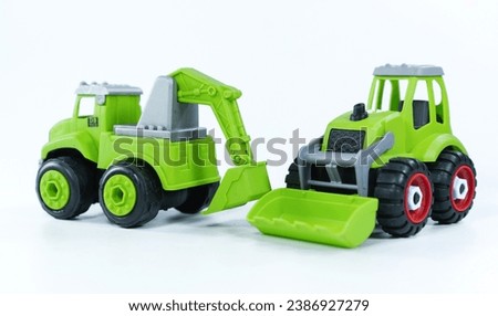 
Children's toy green tractor on a white isolated background.Plastic child toy on white backdrop. Construction vehicle. Children's toy. Tractor Toy.