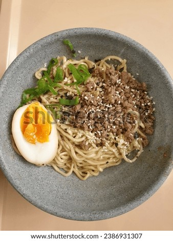 chicken noodles without sauce, topped with boiled egg and sliced ​​spring onions, a little sesame makes it even more delicious