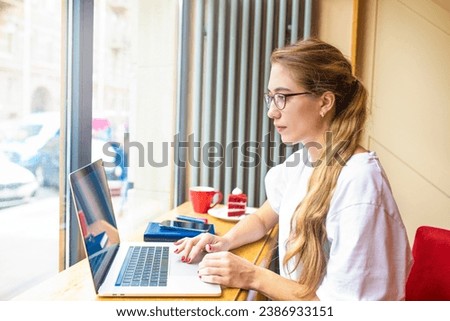 Woman successful digital projects development checking e-mail on notebook gadget while sitting in coffee shop during work break. Female using applications on net-book 