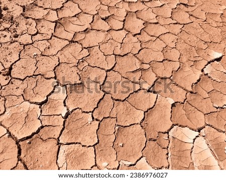 top view cracked red soil ground Earth for texture background,desert cracks,Dry Orange surface Arid,drought land,Picture of natural disaster. drought land Caused by global warming and deforestation.