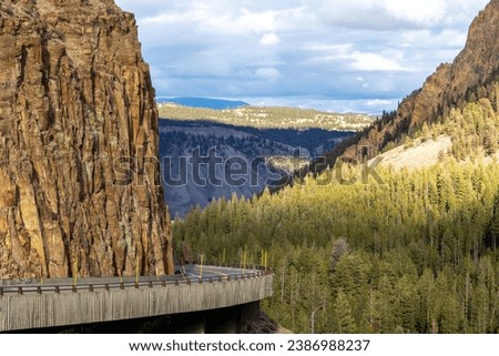 grand loop road at golden gate entering kingman pass in yellowstone national park, image shows the road curving round and descending along the cliff face with the forest background, october 2023 Royalty-Free Stock Photo #2386988237