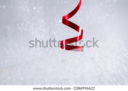 Red wavy ribbon isolated on white littery background. New Year or Christmas holiday decoration concept.