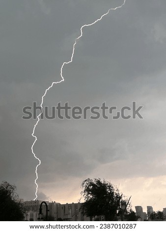 Rainy clouds, laden with moisture, hang low in the sky, casting a gray hue. As they release their payload, gentle or heavy rain falls, transforming the landscape below into a wet and refreshing scene. Royalty-Free Stock Photo #2387010287