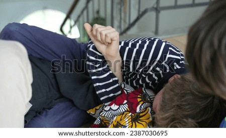 Family Feud - Brothers on Floor in Heated Wrestling Match. Indoor Sibling FIGHT - Brothers Wrestling and Quarreling on Floor Royalty-Free Stock Photo #2387030695