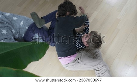 Family Feud - Brothers Engaged in Heated Floor Wrestling. Sibling Showdown of Brothers Wrestling and Arguing on the Floor Royalty-Free Stock Photo #2387030697