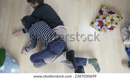 Family Feud - Brothers Engaged in Heated Floor Wrestling. Sibling Showdown of Brothers Wrestling and Arguing on the Floor Royalty-Free Stock Photo #2387030699
