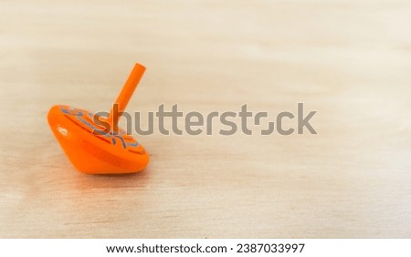 An orange spinning top svivon for Hanukkah. a big miracle happened here. On the background of a white wooden surface
with free space for text. for Hanukkah, Jewish holiday, festival of lights  