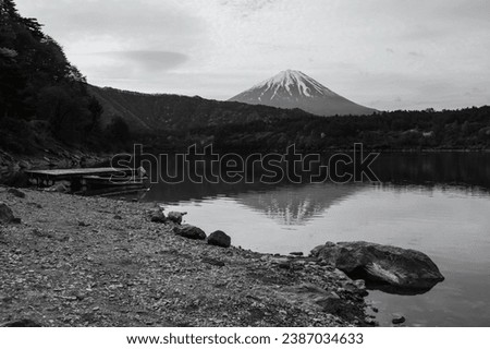lake Saiko with floating boat and mount Fuji in morning with skyline reflection, Yamanashi, Japan. 1 of 5 famous Fuji lakes to make holiday vacation maker. Black and white process.