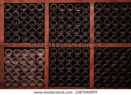 Wine bottles sit stacked in winery,
