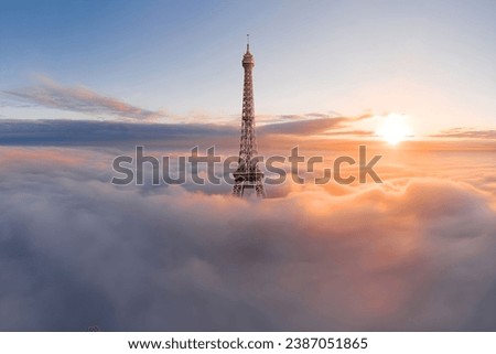 The Eiffel Tower, Paris, France in clouds with golden hours, sun, sunrise, sunset. Symbol of the Capital and France.