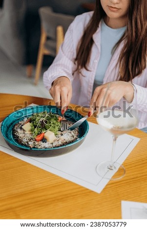 Young attractive woman enjoys tasty meal on cafe or restaurant background