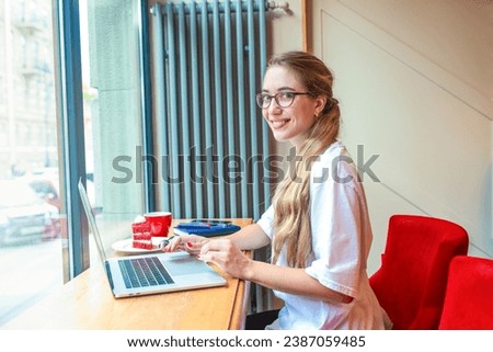 Happy smiling woman successful social media manager looking in camera while sitting in co-working during freelance work on notebook gadget 