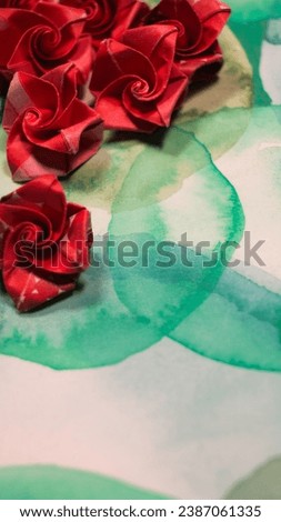 green watercolor with red origami roses