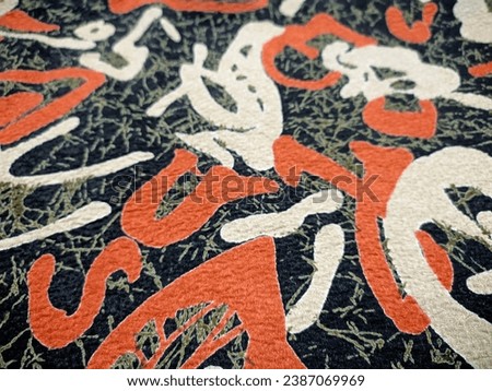 photo of a piece of clothing with a black base color and abstract orange ornaments