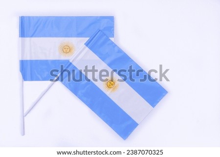 Pair of Argentine plastic flags on white background. Patriotic symbols