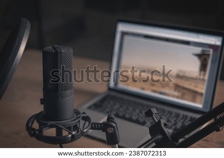 Home studio for podcasts. Large Microphone, laptop and notebooks on the table. Close-up. Cinematic