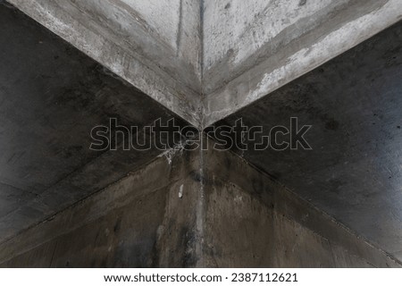 Close up architectural detail of the intersection of two gritty concrete corridors. Royalty-Free Stock Photo #2387112621