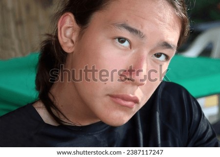 Close-up Portrait head shot photo of a young handsome good looking eurasian caucasian chinese male boy with long hair dresses in a ponytail pony  hairstyle with smiling amuzed happy neutral expression